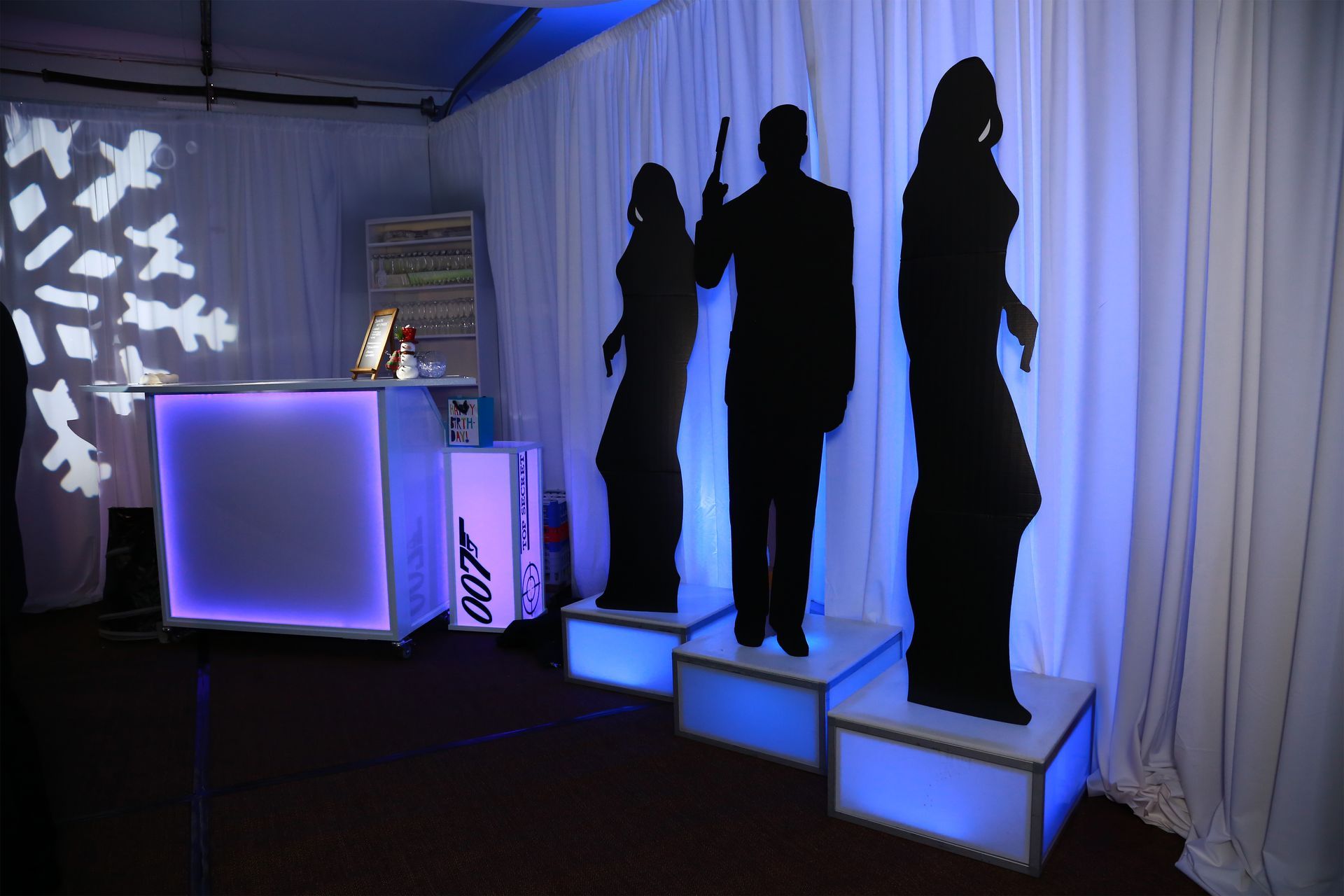 A man and a woman are standing on a stage in front of a white curtain.