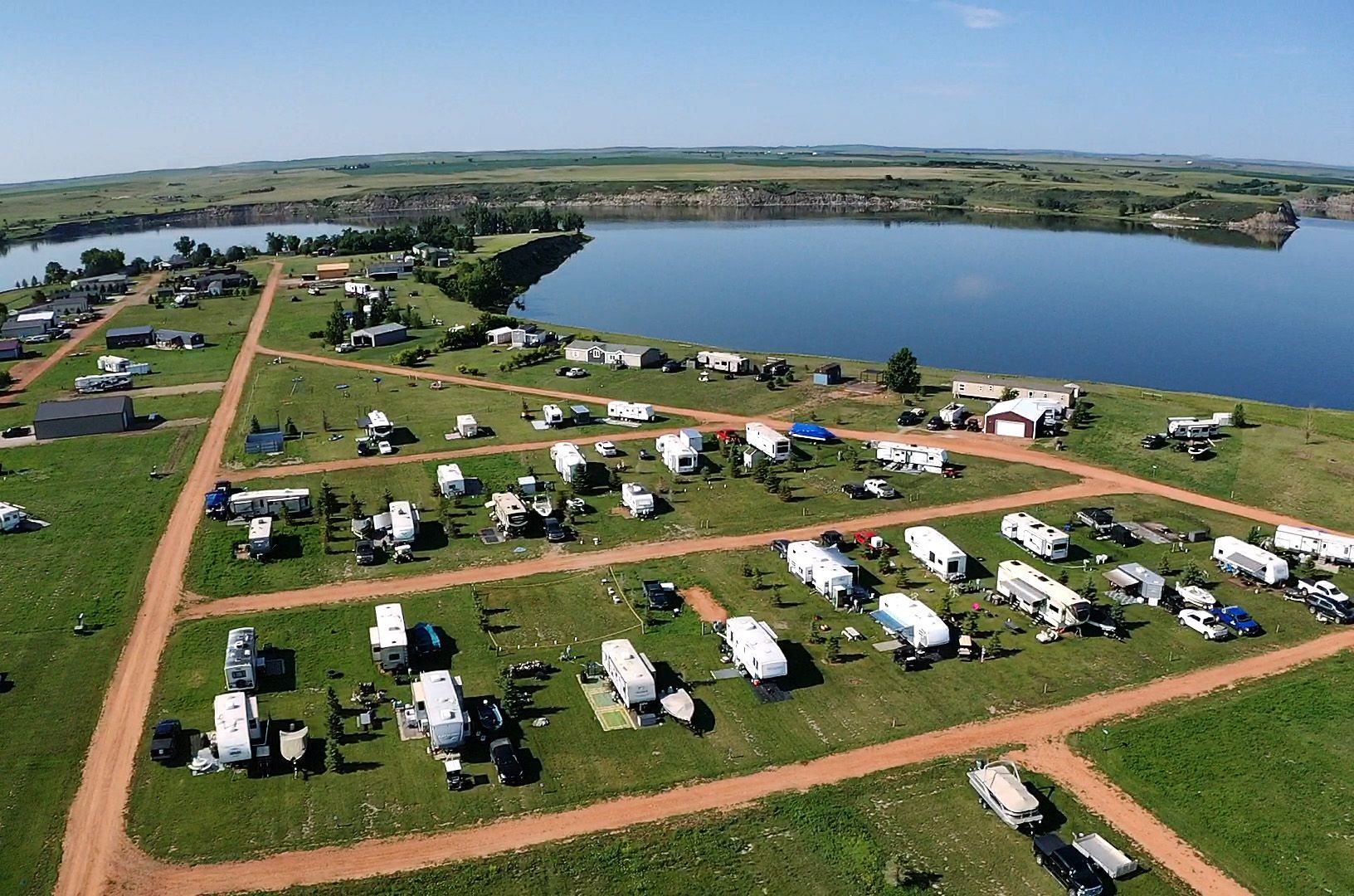 An aerial view of a campground with a lake in the background.