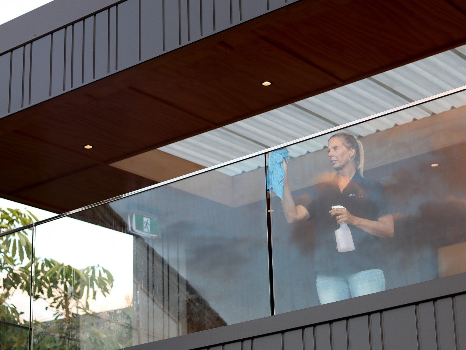 A woman is cleaning a balcony with a spray bottle