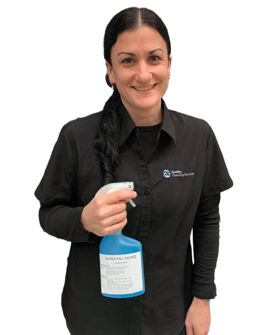 A woman in a black shirt is holding a spray bottle.