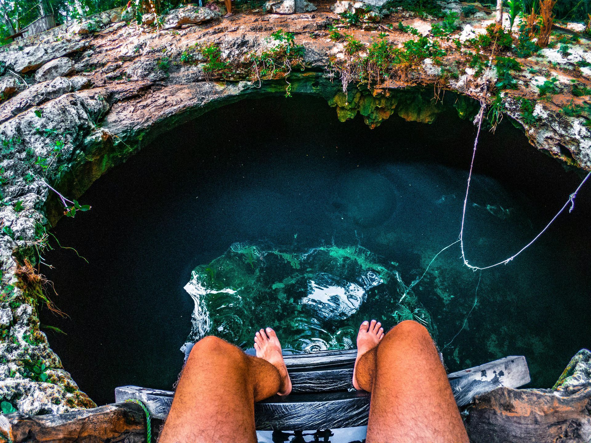 Una persona está sentada en una escalera con vistas a un estanque de agua.