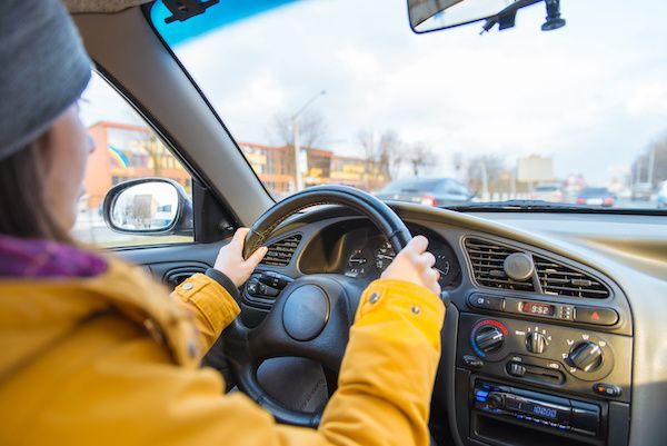 A woman in yellow jacket driving | Autotrends