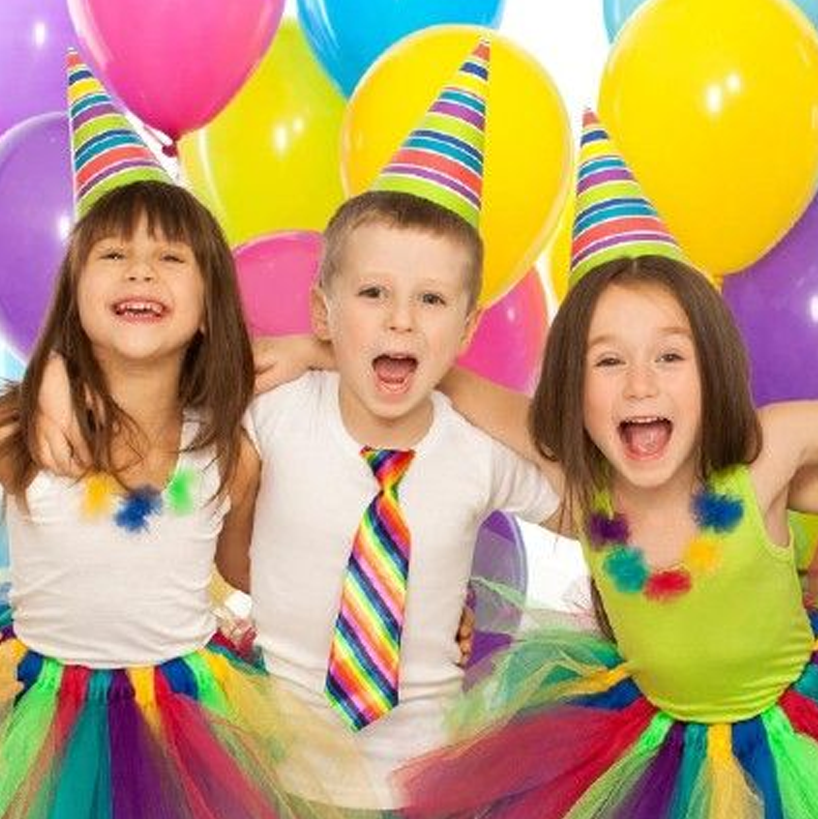 Three children wearing party hats and ties are posing for a picture with balloons in the background