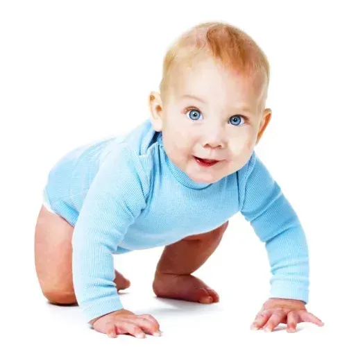 A baby in a blue shirt is crawling on the floor.
