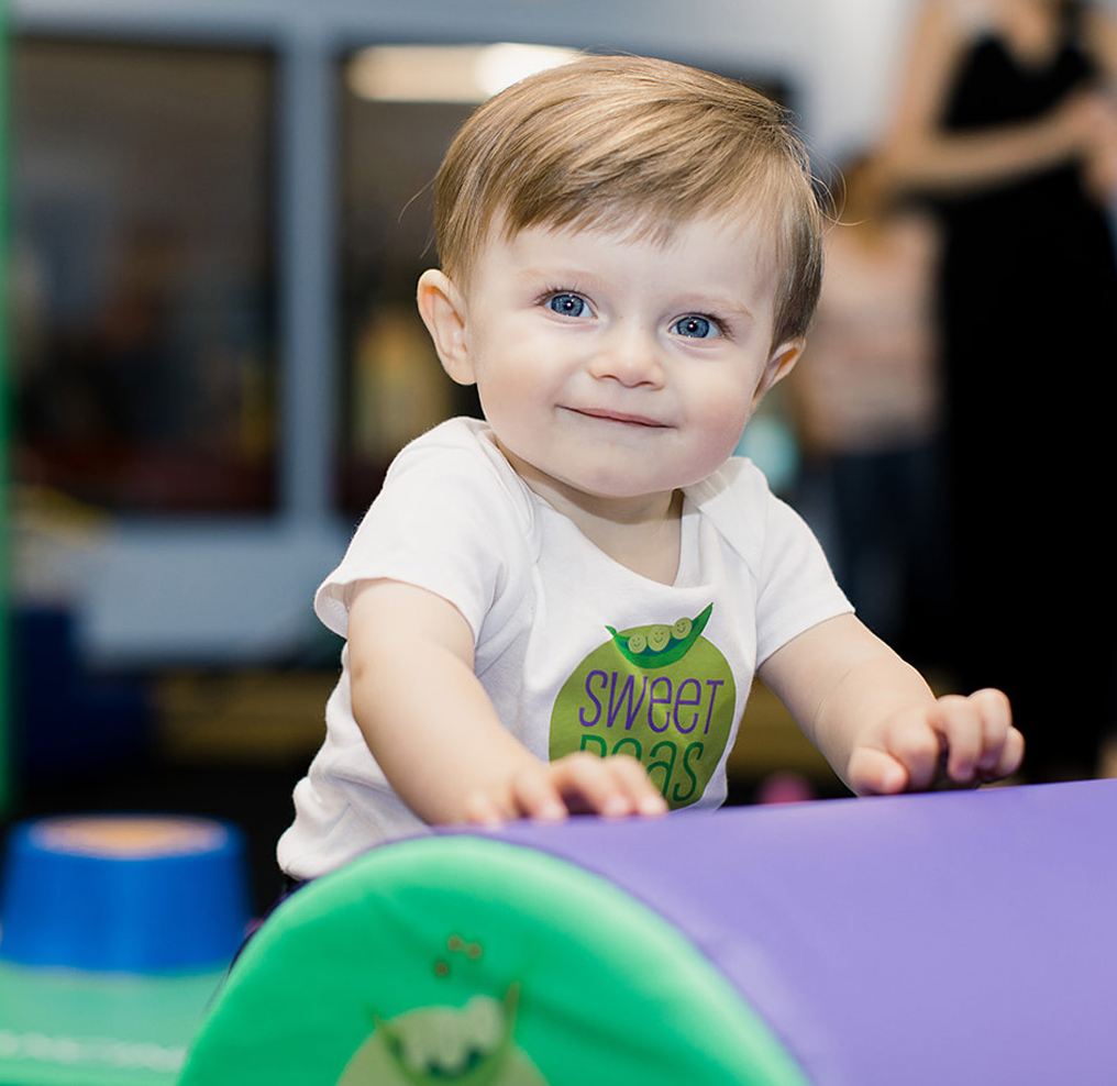 A baby wearing a shirt that says sweet pea on it
