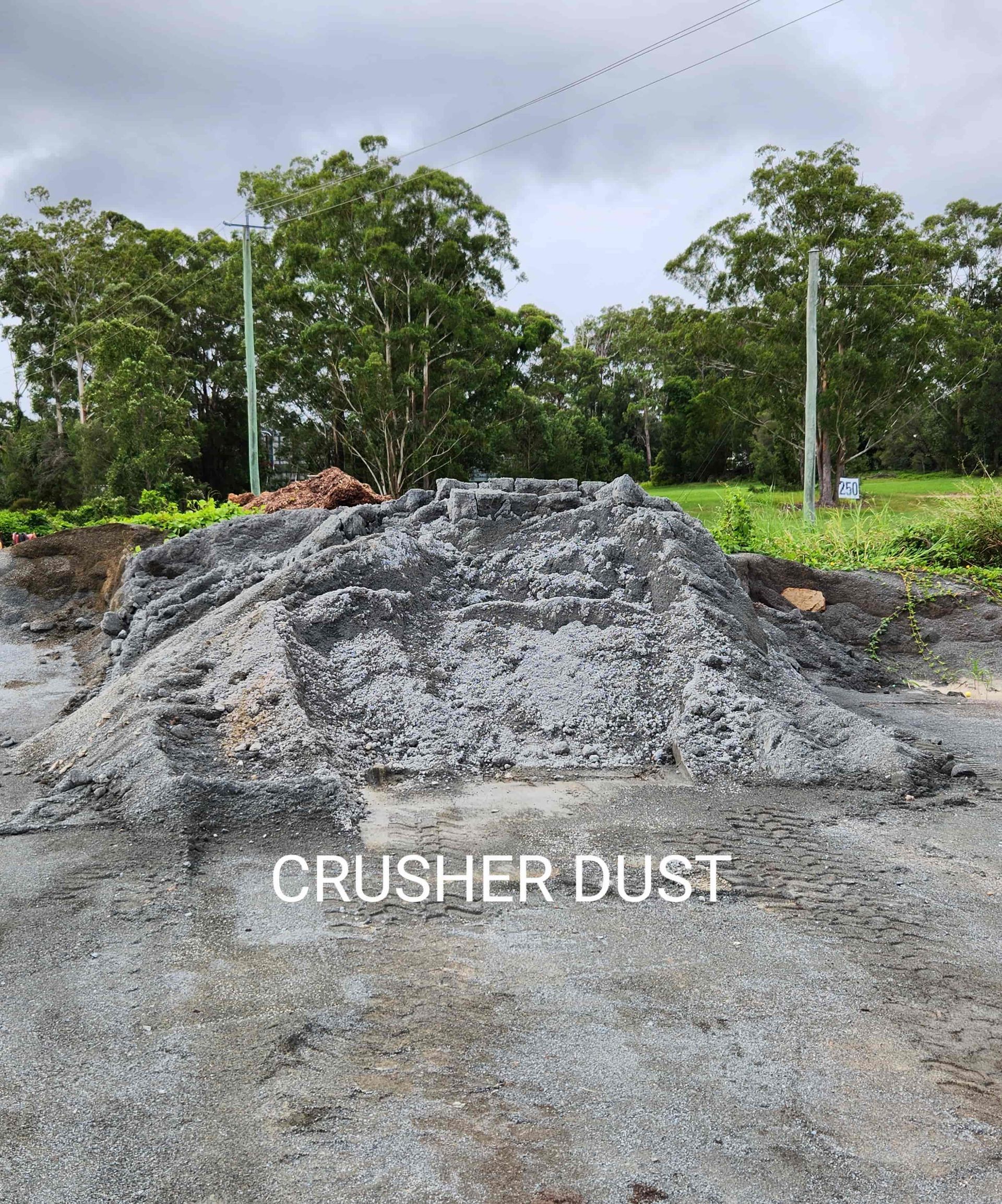 A Pile of Crushed Dust is Sitting on Top of a Dirt Field — T&G Sand and Gravel In Sippy Downs, QLD