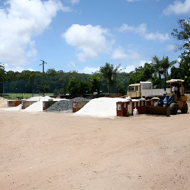 A Tractor Is Parked In A Dirt Area With A Truck In The Background — T&G Sand and Gravel In Sippy Downs, QLD