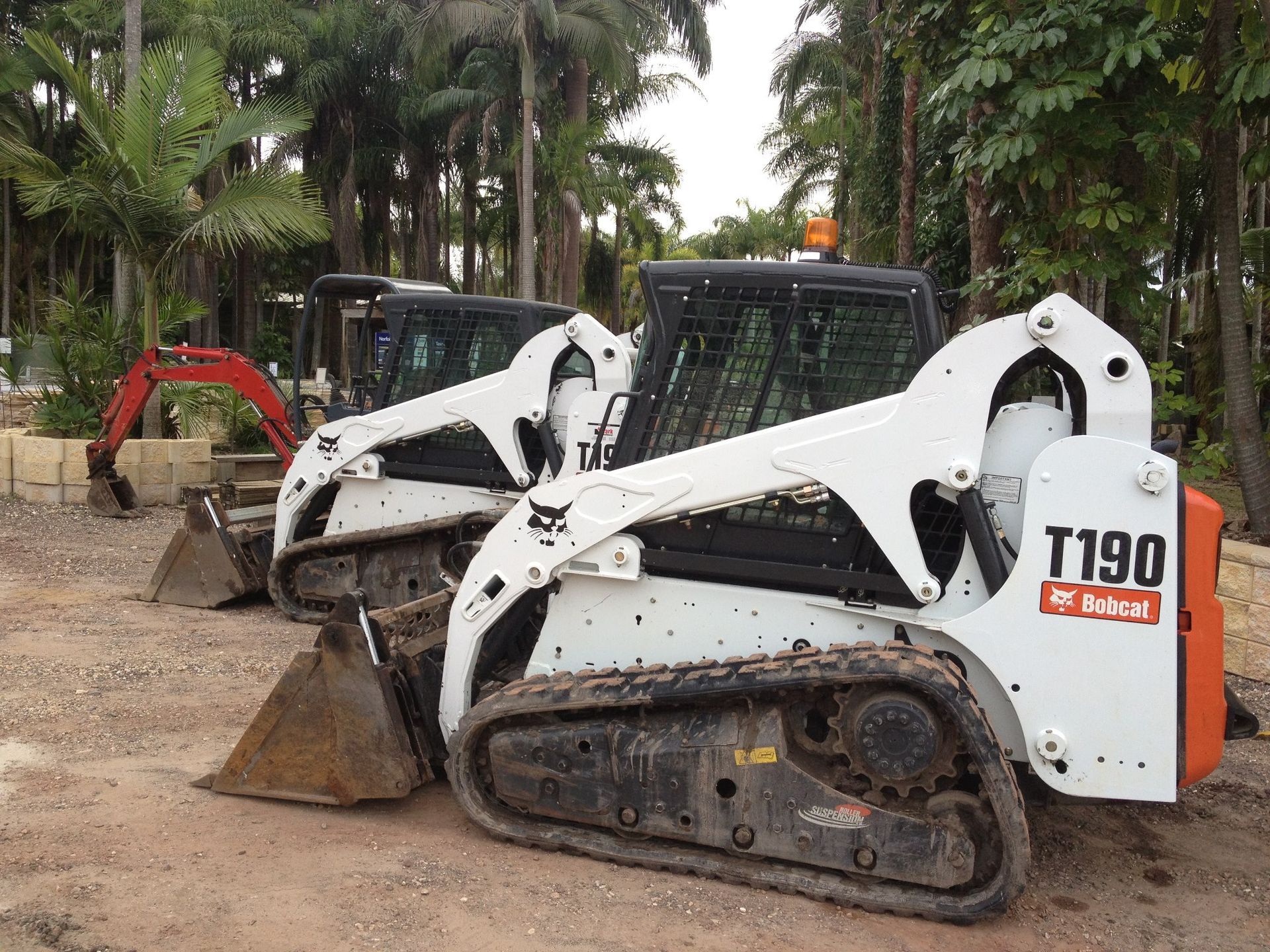 Two Bobcat T190 Tractors Are Parked Next To Each Other In A Dirt Field — T&G Sand and Gravel In Sippy Downs, QLD
