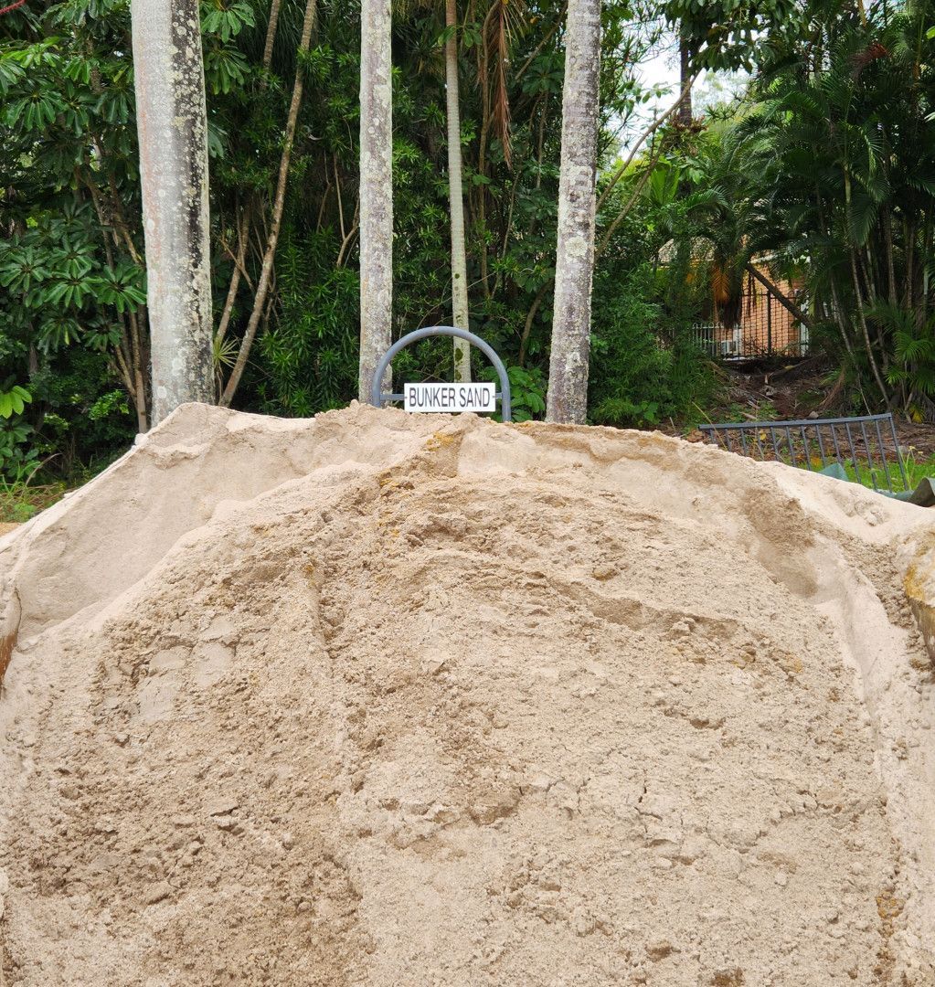 Pile of Tan Sand in Front of Trees With a Sign — T&G Sand and Gravel In Sippy Downs, QLD