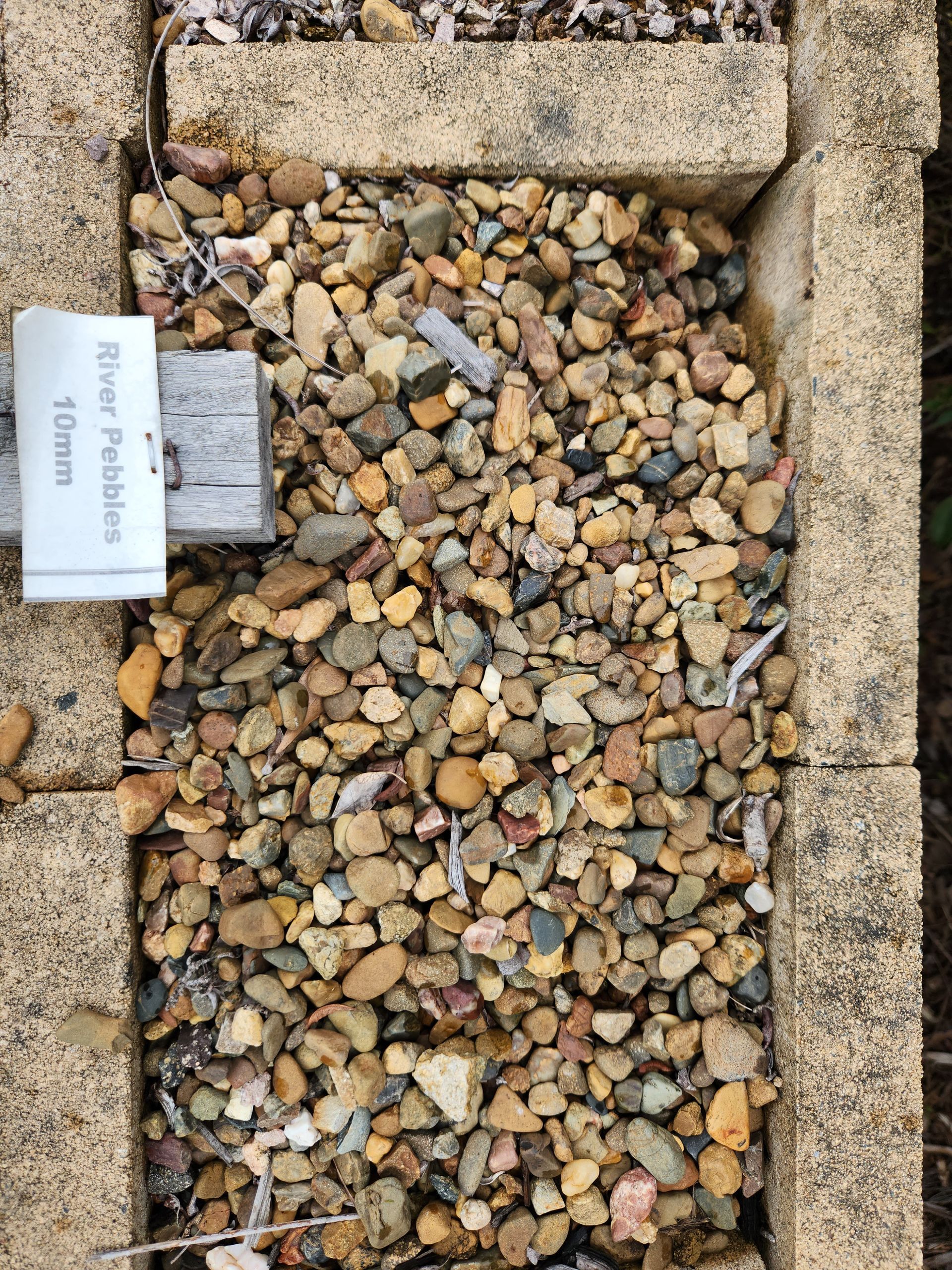Gravel Bed With Tan-colored River Pebbles — T&G Sand and Gravel In Sippy Downs, QLD