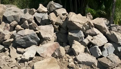 A Pile Of Rocks Is Sitting On Top Of A Dirt Field — T&G Sand and Gravel In Sippy Downs, QLD