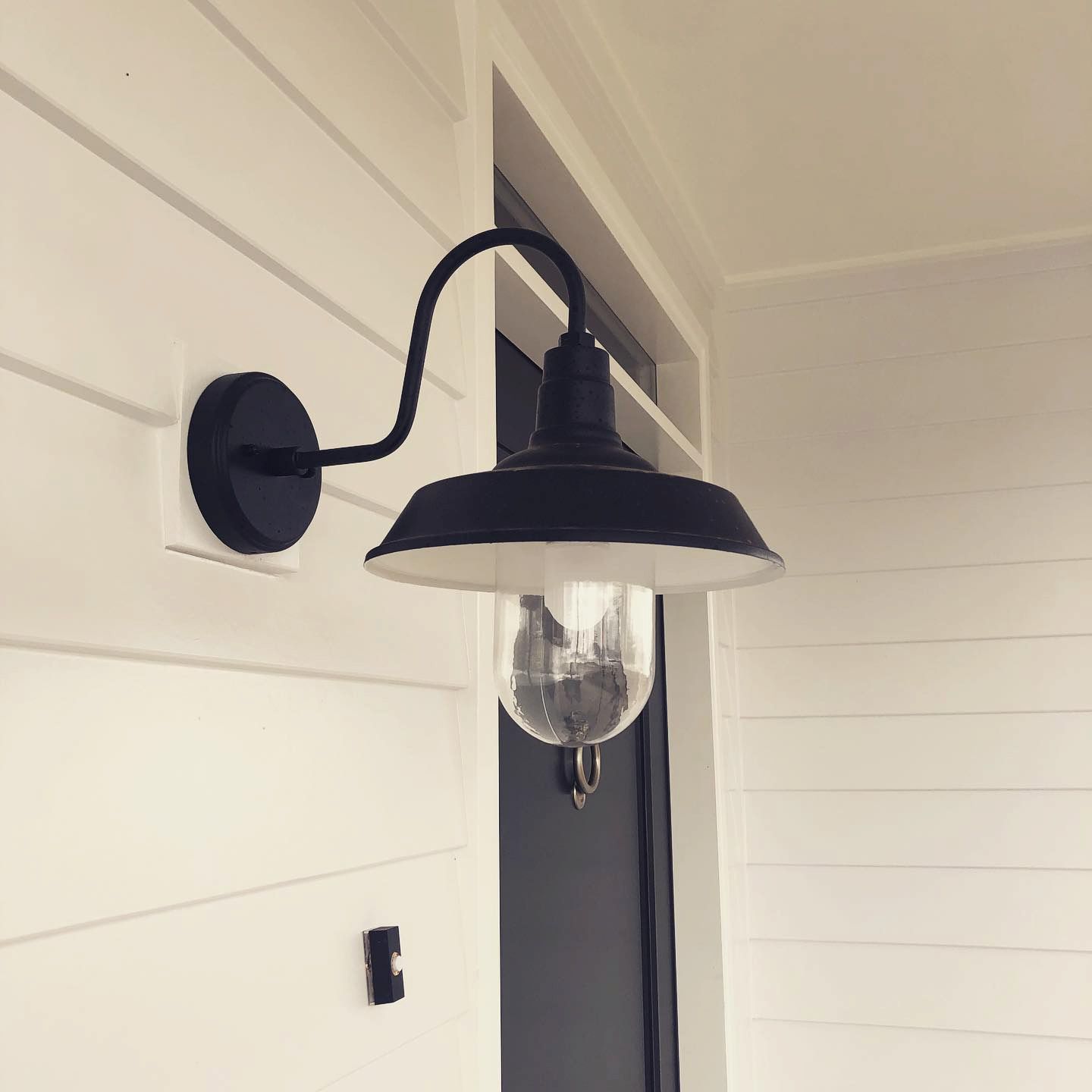 Black Outdoor Wall Light Fixture on White Siding — Brett Cox Electrical and Solar in Gumly Gumly, NSW