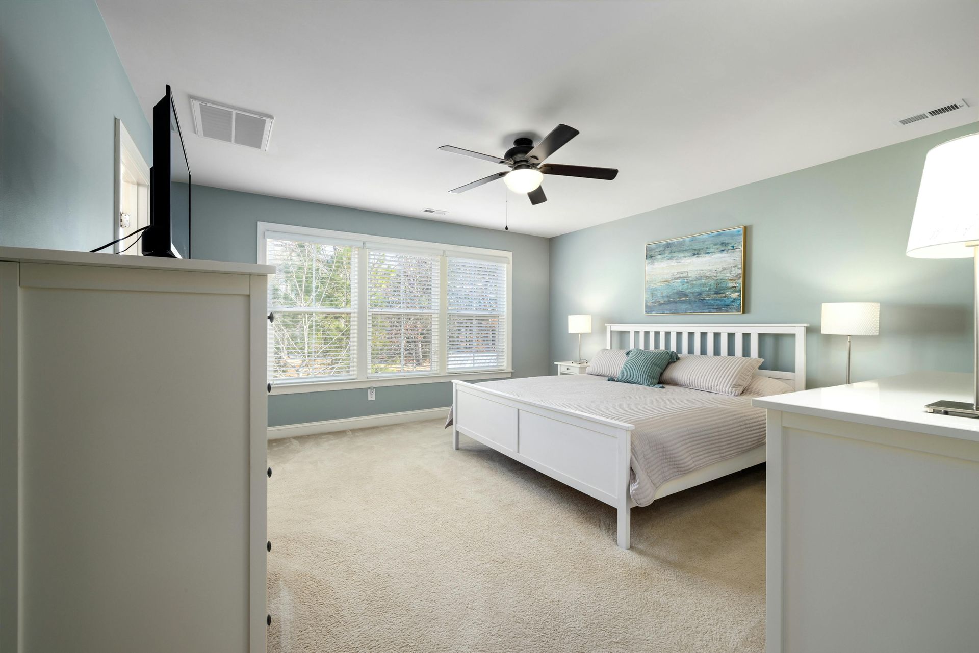 A Bright, Airy Bedroom Featuring a White Bed — Brett Cox Electrical and Solar in Gumly Gumly, NSW