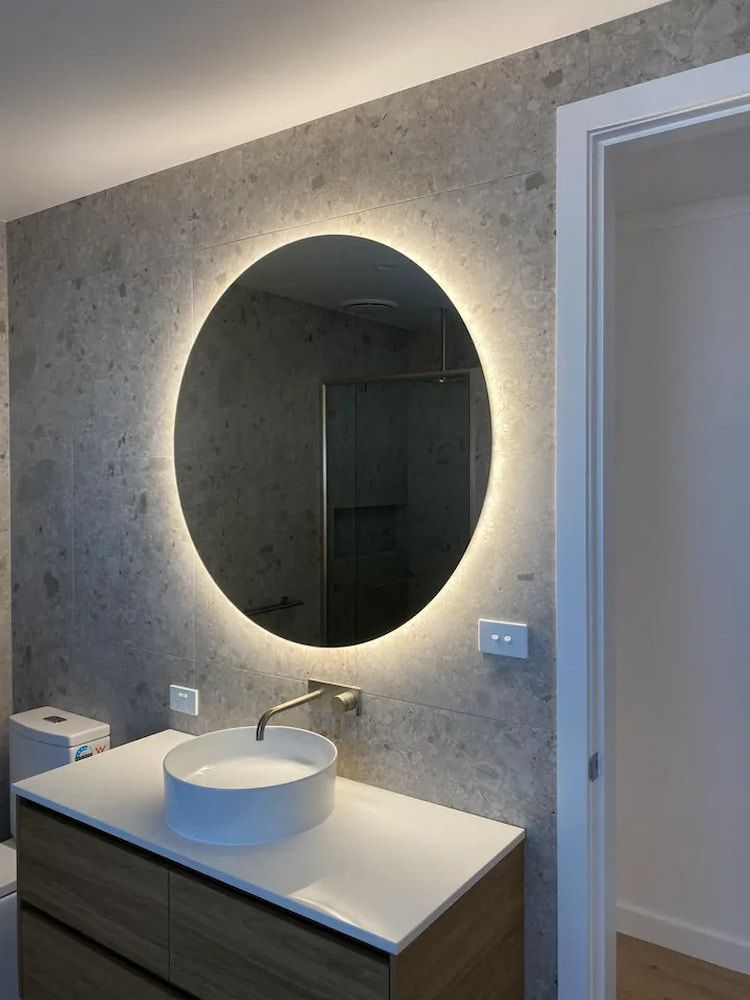 Bathroom With Round Mirror With Backlighting and Sink — Brett Cox Electrical and Solar in Gumly Gumly, NSW