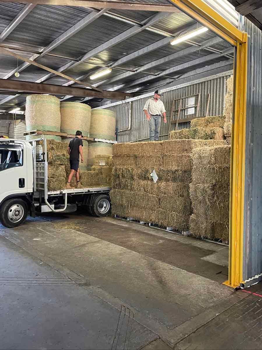 A Truck Is Loading Hay Bales Into A Warehouse — Dillon Rural In Port Macquarie, NSW