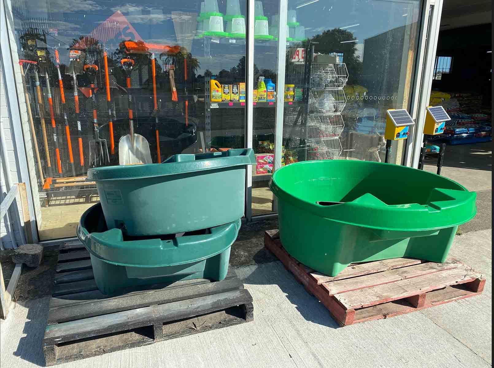 Two Green Containers Are Sitting On A Wooden Pallet Outside Of A Store — Dillon Rural In Wauchope, NSW