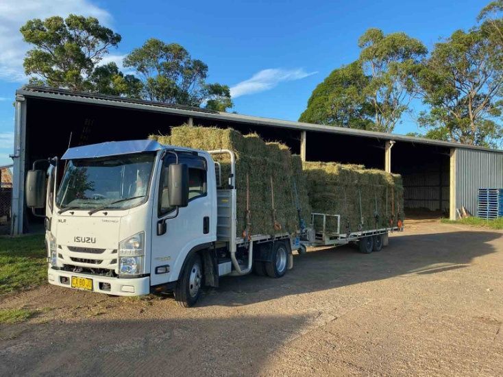 A White Truck Is Carrying Hay On A Trailer — Dillon Rural In Wauchope, NSW
