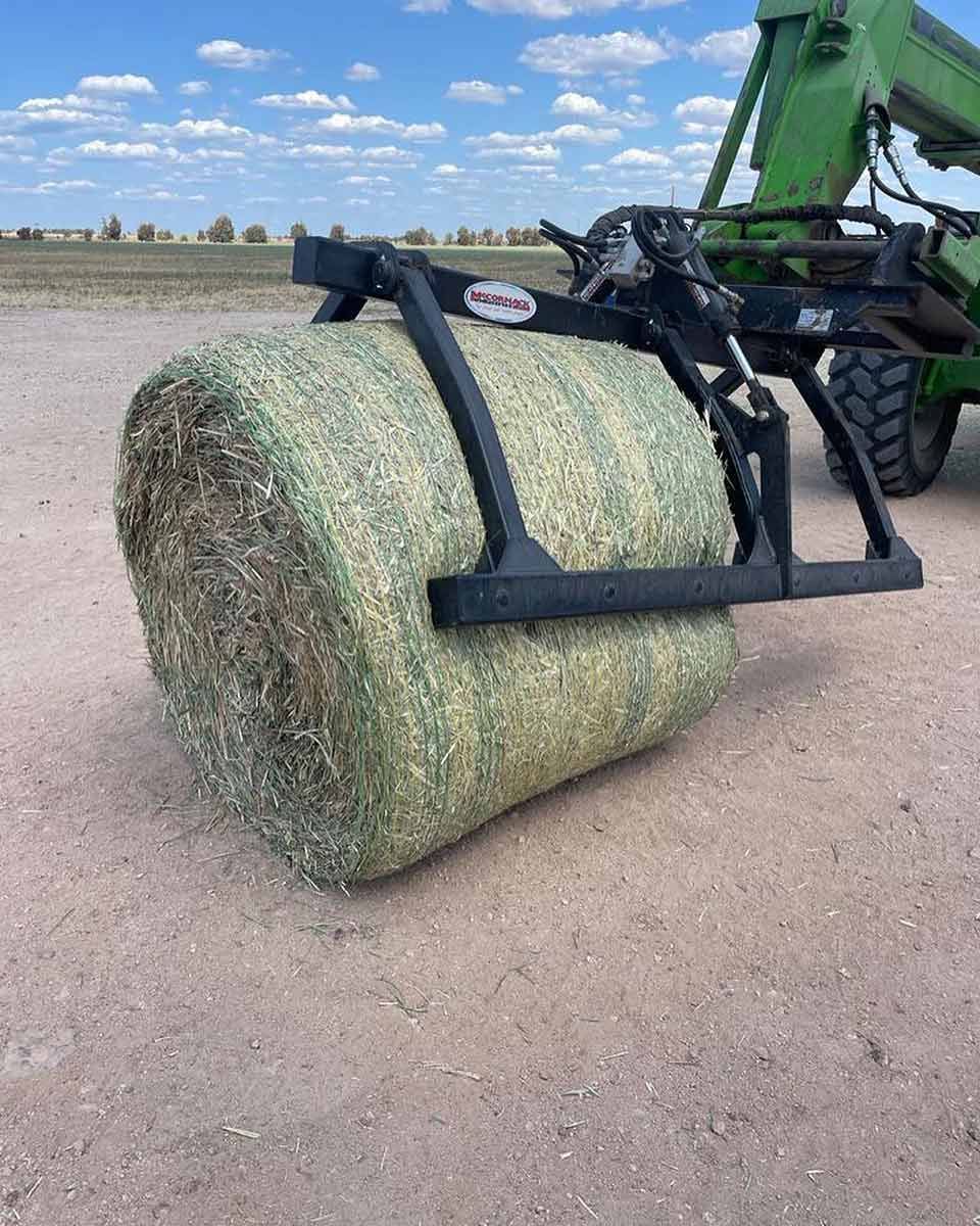 A Bale Of Hay Is Being Lifted By A Tractor — Dillon Rural In Cundletown, NSW