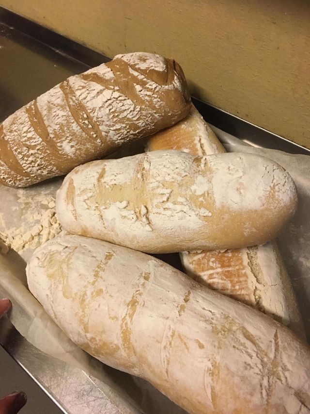 Un mucchio di pagnotte di pane sono adagiate una sopra l'altra su un vassoio.