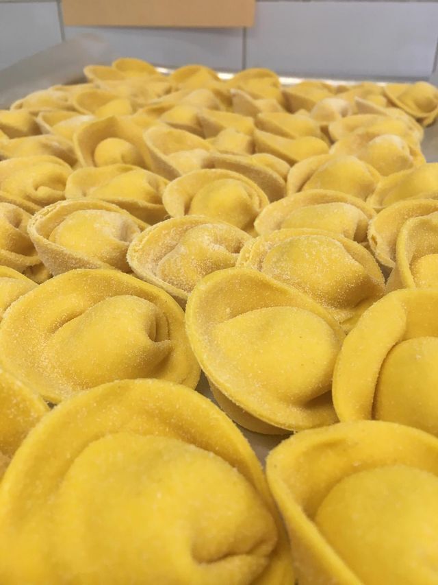 Un mucchio di gnocchi gialli sono sistemati uno sopra l'altro su un tavolo.