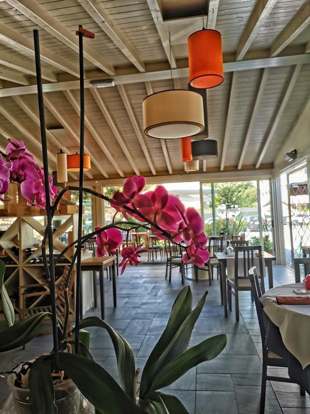 Un ristorante con tavoli e sedie e fiori viola