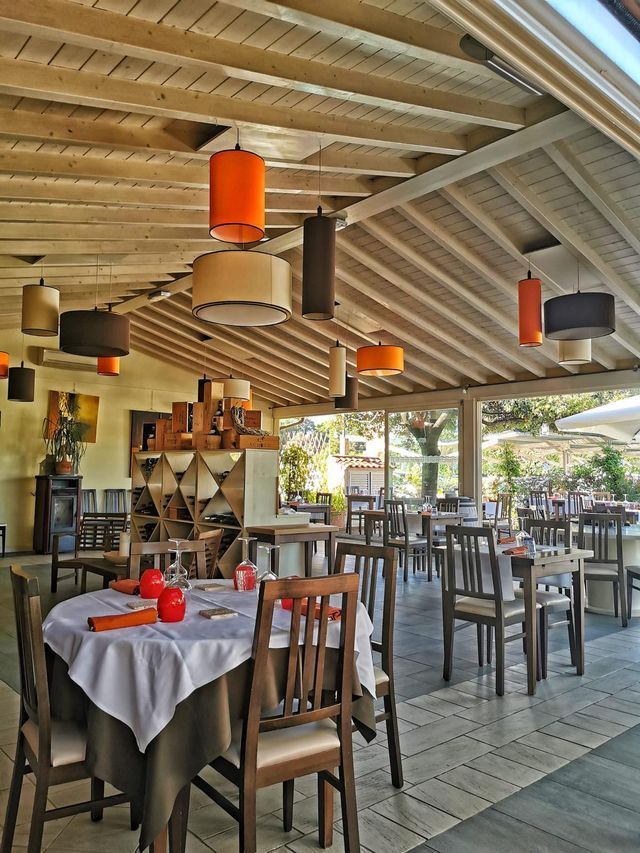 Un ristorante con tavoli, sedie e lampade appese al soffitto