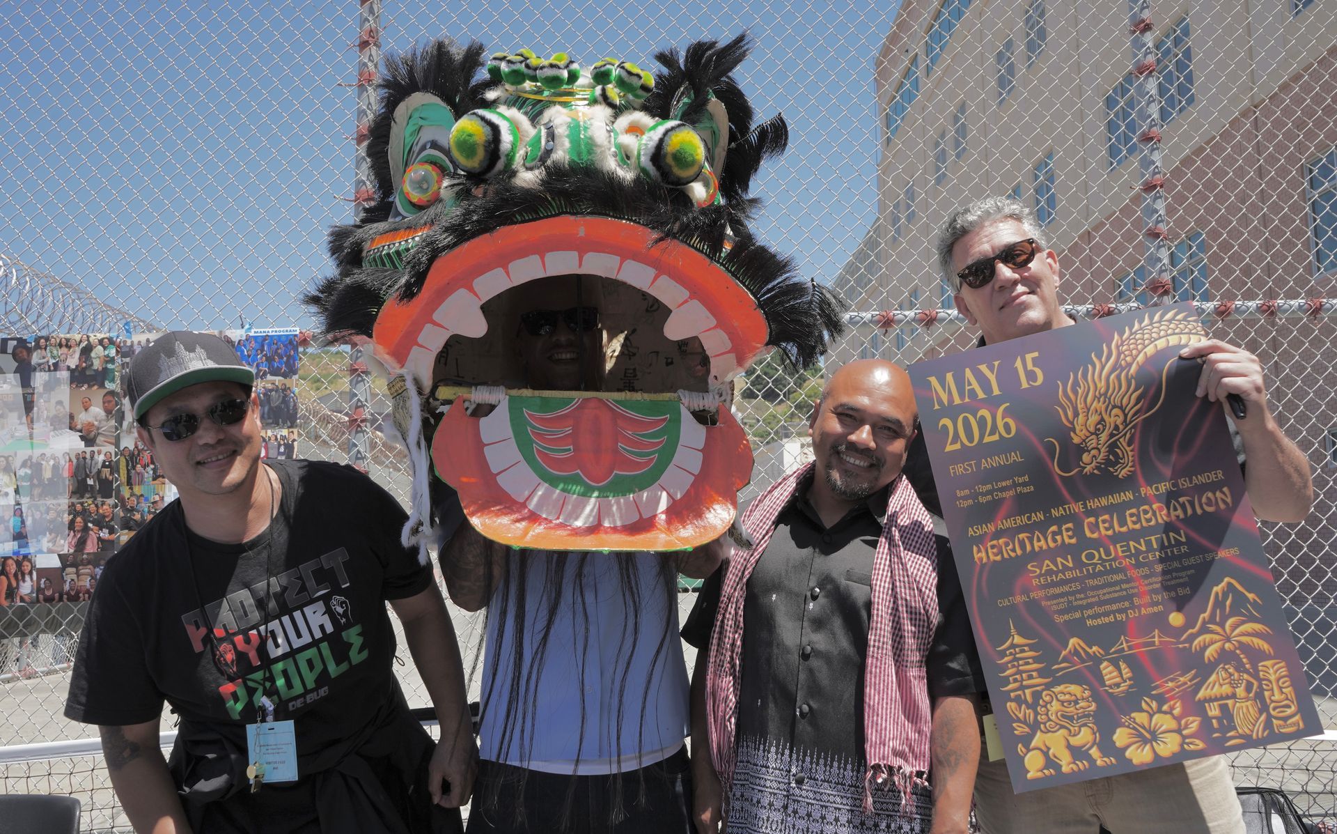 Four people pose with a colorful dragon mask at a sunny outdoor festival