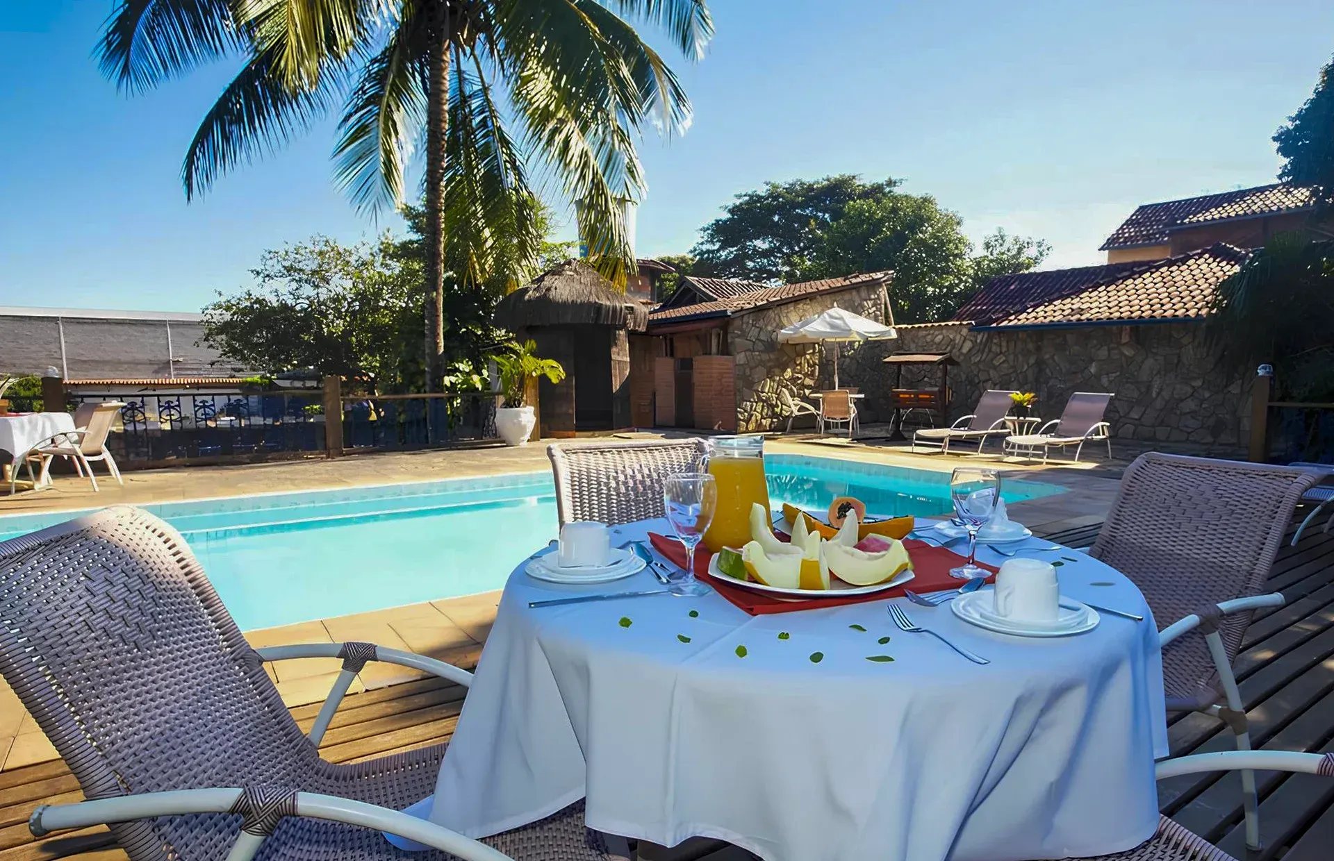 Uma mesa com um prato de comida em frente a uma piscina.