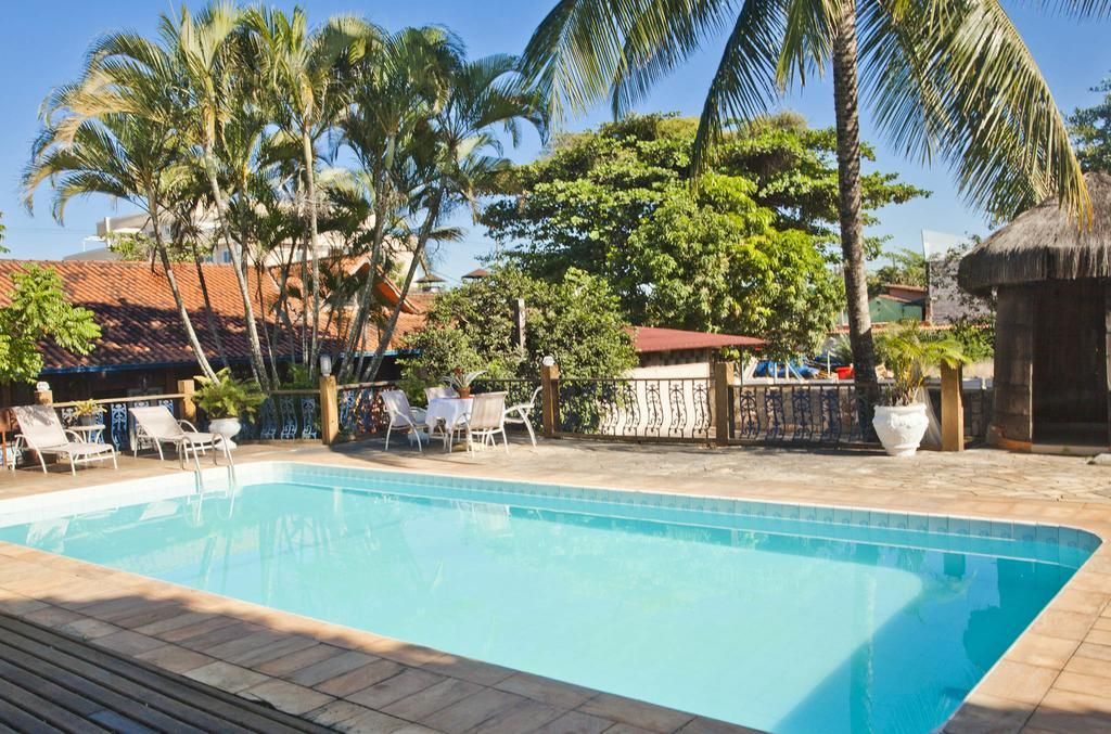 Uma grande piscina rodeada por palmeiras e cadeiras.