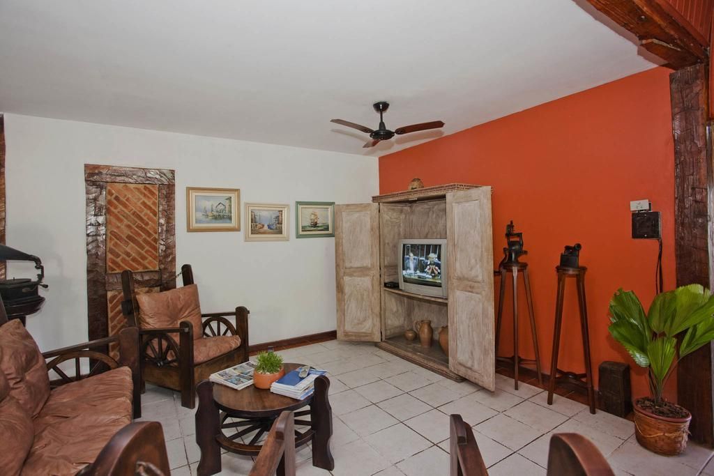 Uma sala de estar com ventilador de teto e televisão