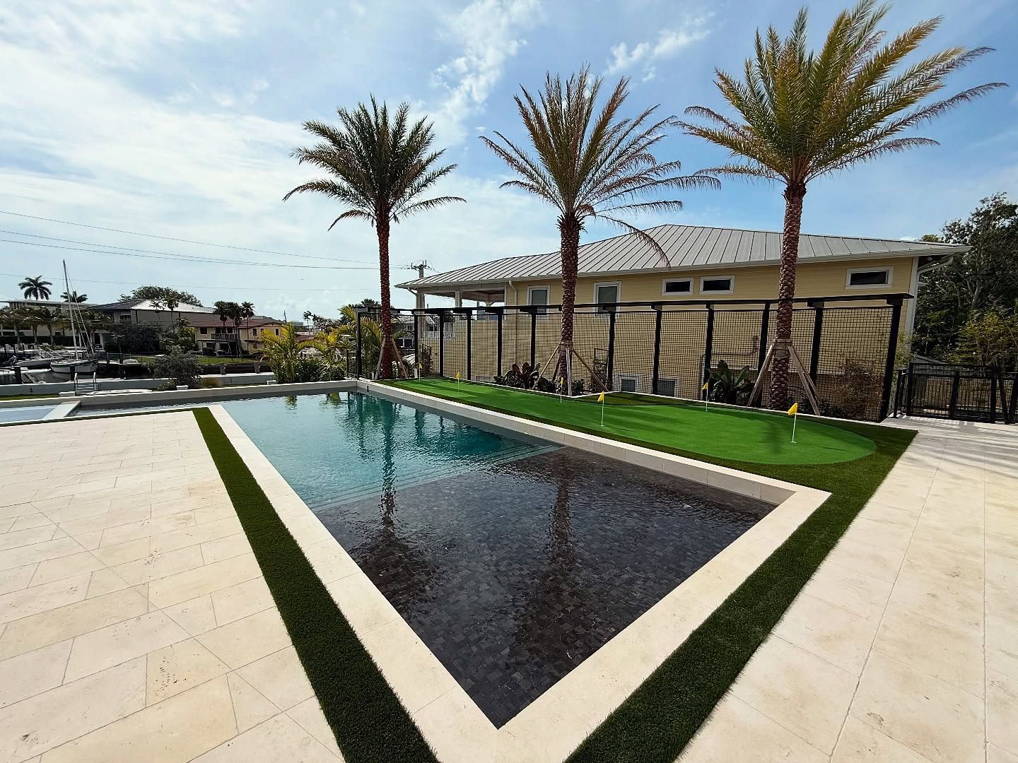 Luxury backyard renovation in South Florida with custom pool and artificial turf