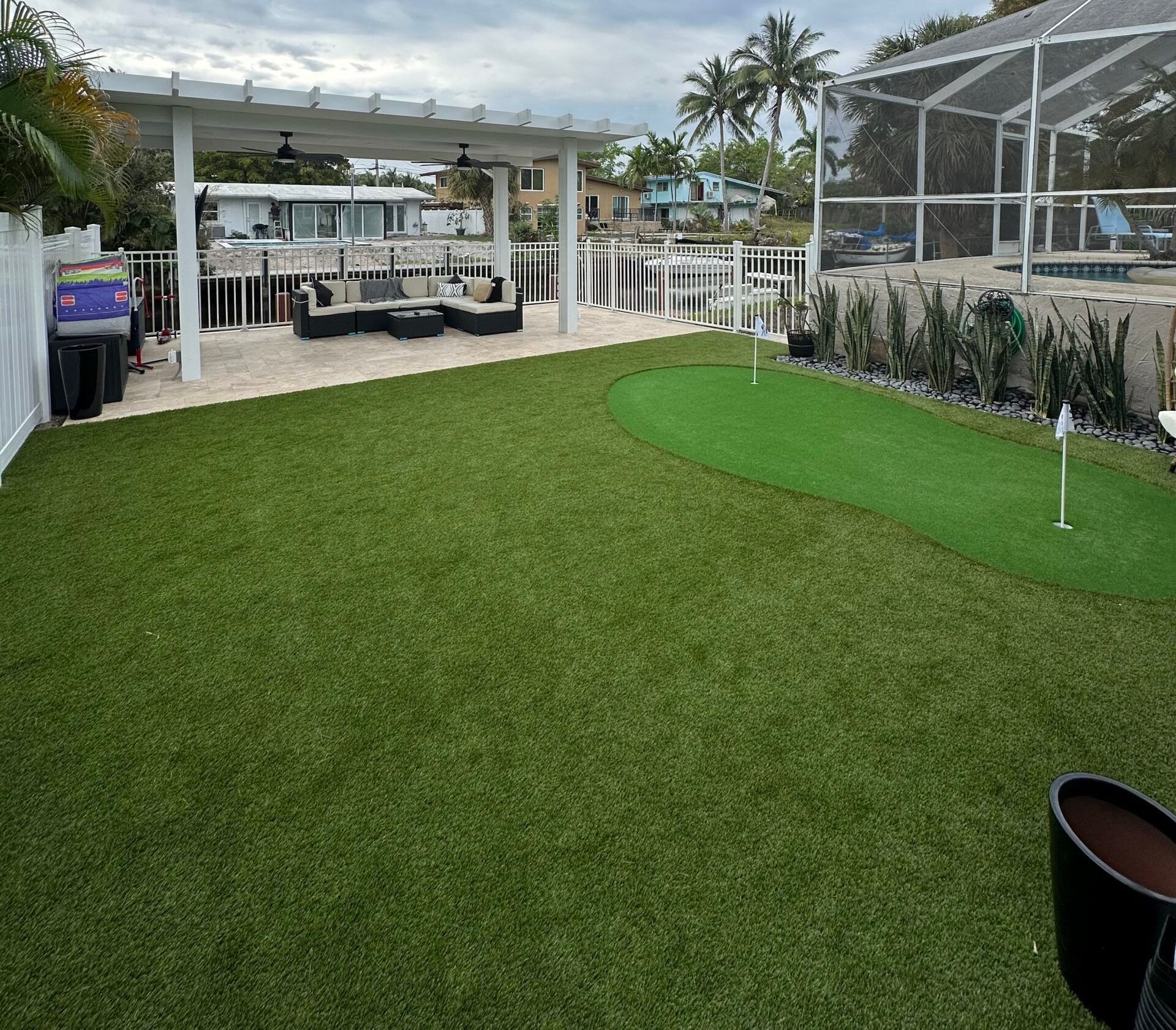 Artificial turf backyard installation in Palm Beach with putting green
