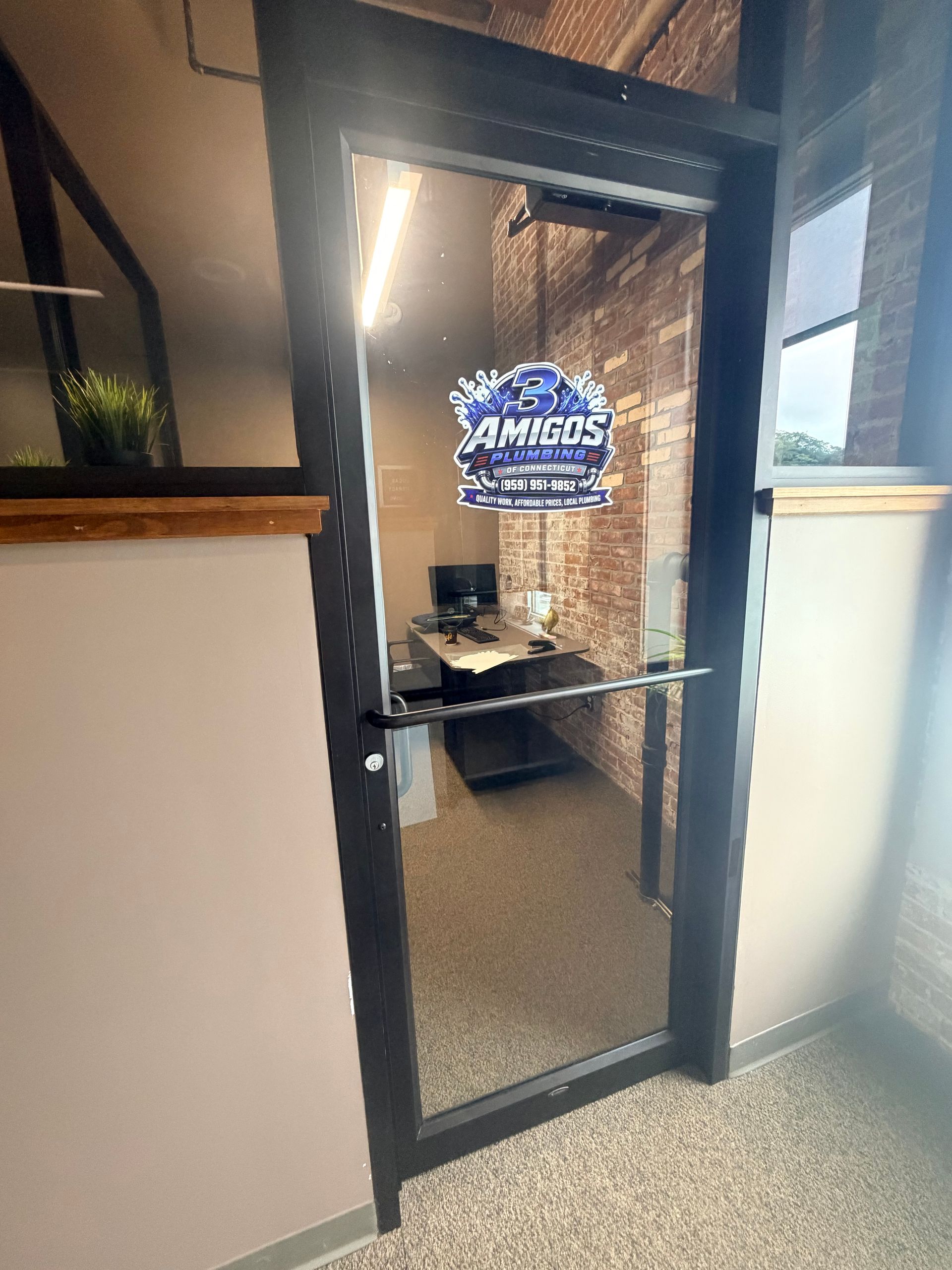 Glass office door with a blue security sign in a carpeted hallway
