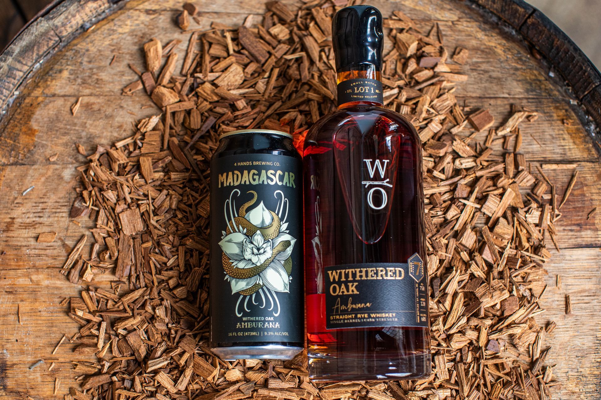 4 Hands Brewing Company's Madagascar Withered Oak Amburana can and a bottle of Withered Oak Amburana whiskey