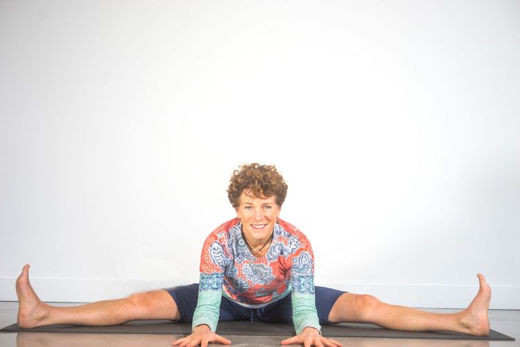 A man is stretching his legs on a yoga mat