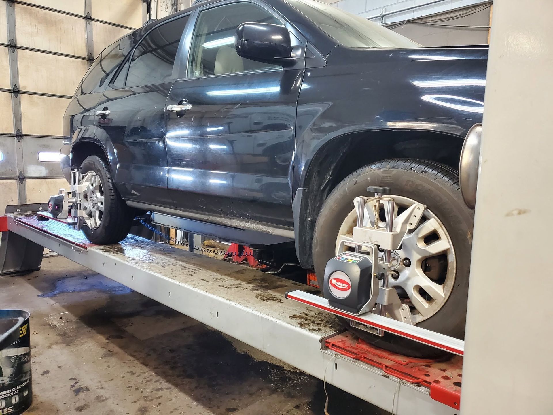 Black SUV On Alignment Service Lift | JK Auto And Truck Repair