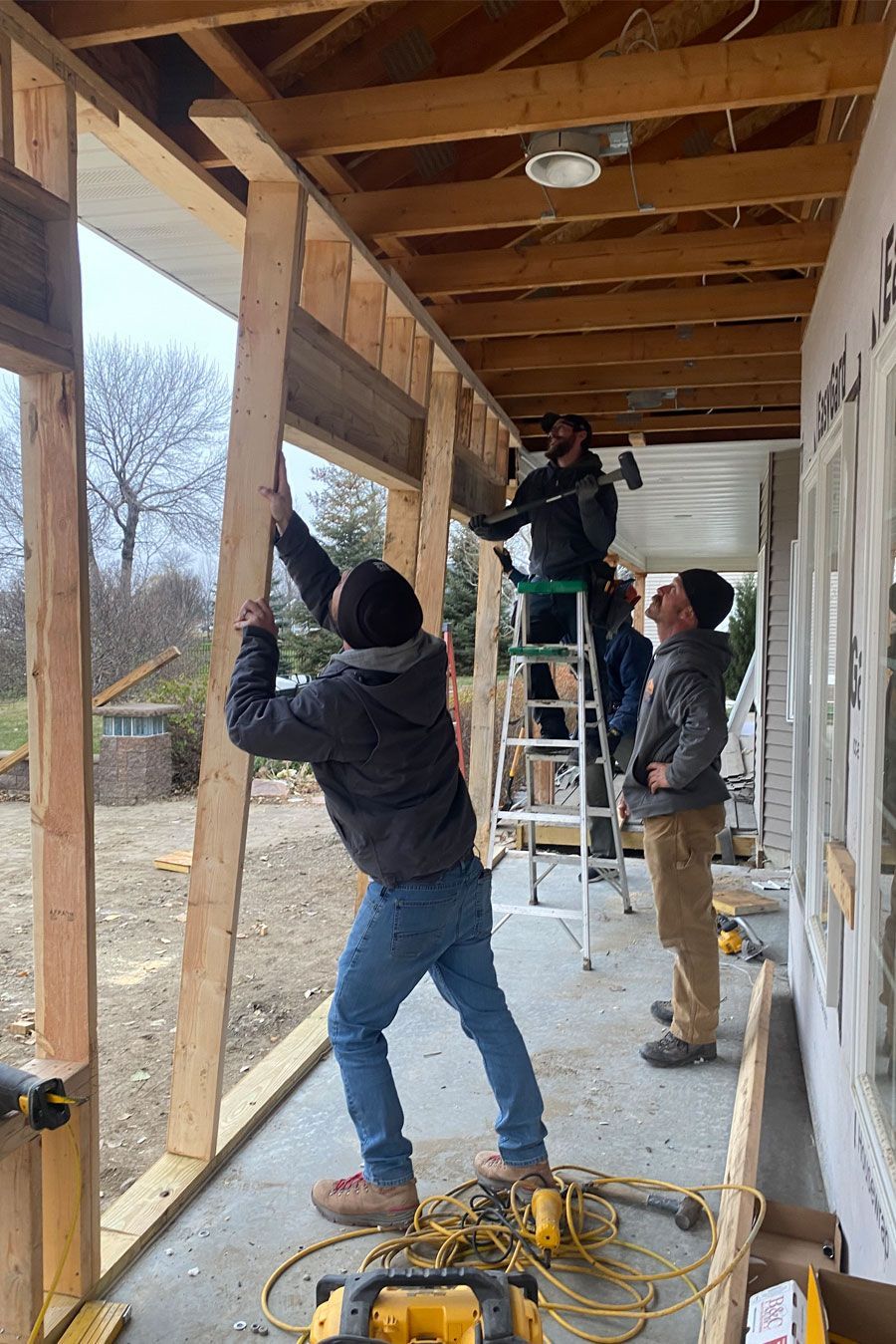 a group of people are working on a wooden structure .