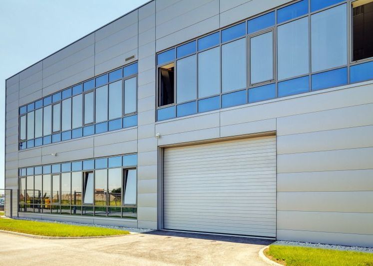A large building with a lot of windows and a garage door.