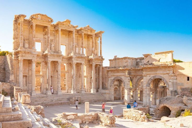 Sunlit ancient stone ruins with arches and columns under a blue sky