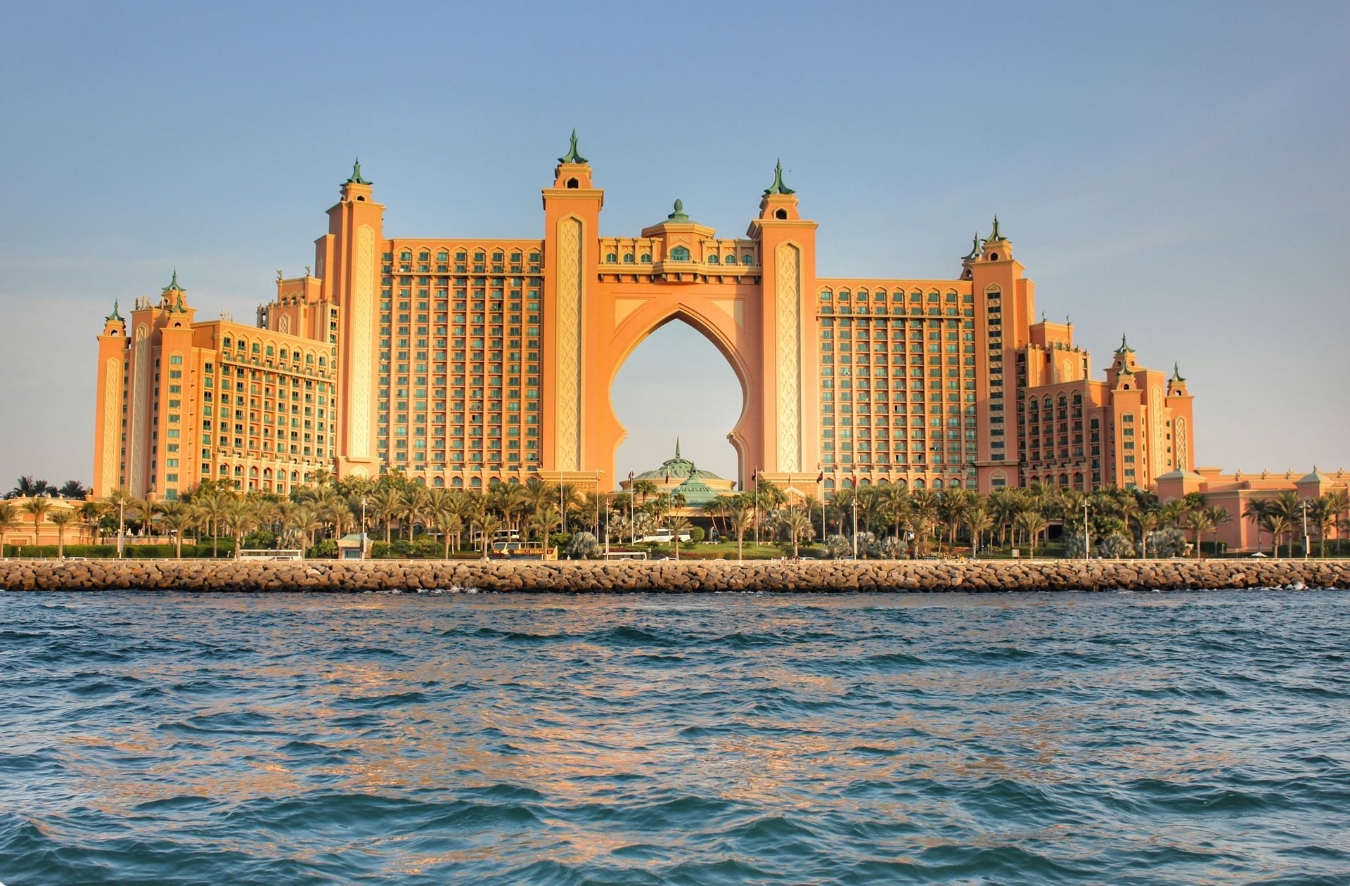 Atlantis The Palm hotel in Dubai at sunset, with ocean water in the foreground