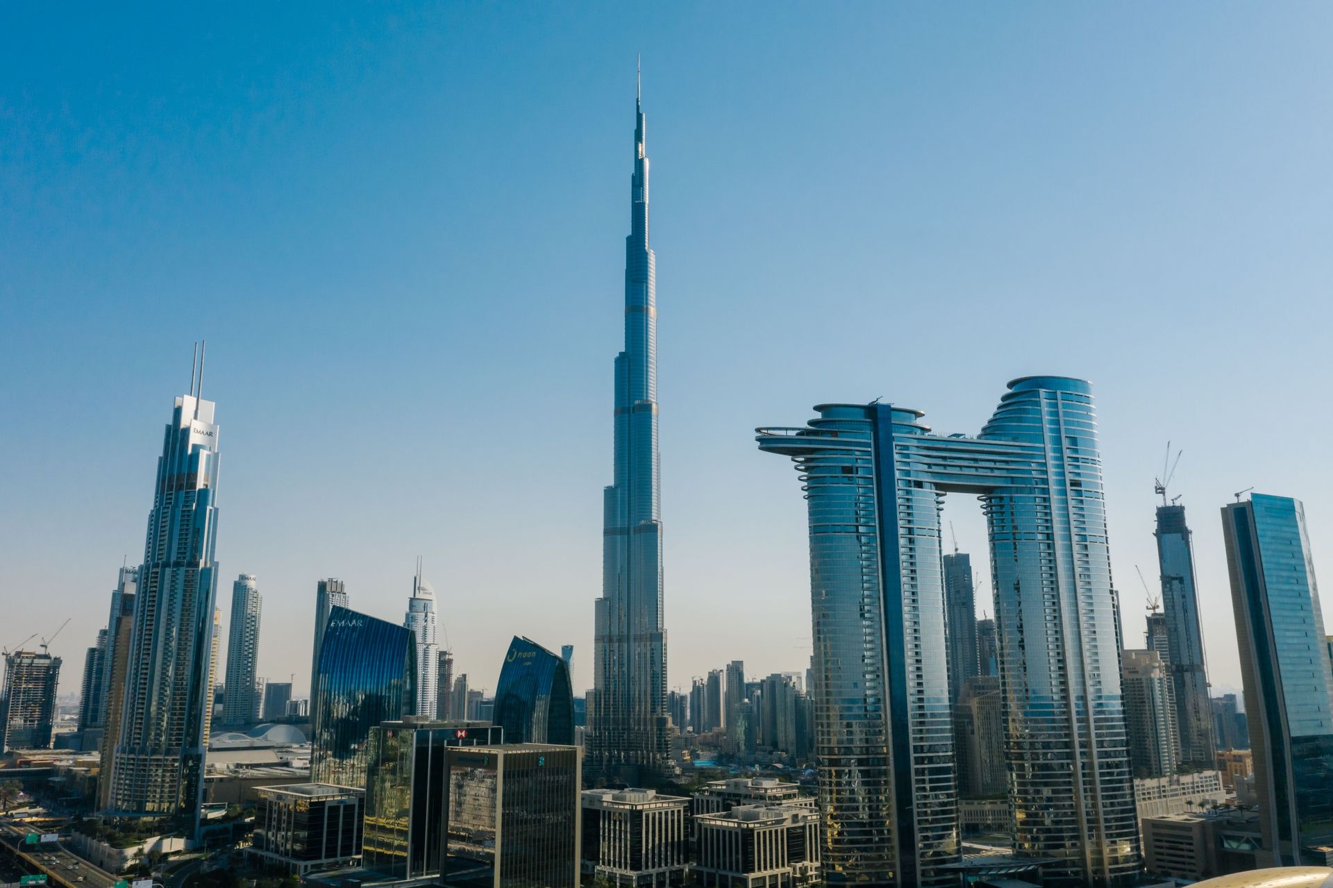 Dubai skyline with the Burj Khalifa centered among modern glass skyscrapers under a clear sky