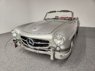 A classic silver Mercedes-Benz convertible parked indoors in a well-lit studio setting.