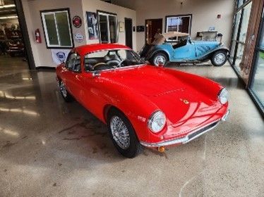 A bright red classic car parked indoors.