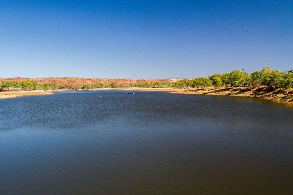 A Large Body of Water Surrounded by Trees on A Sunny Day — Watto's Earthmoving & Machinery Hire in Atherton, QLD