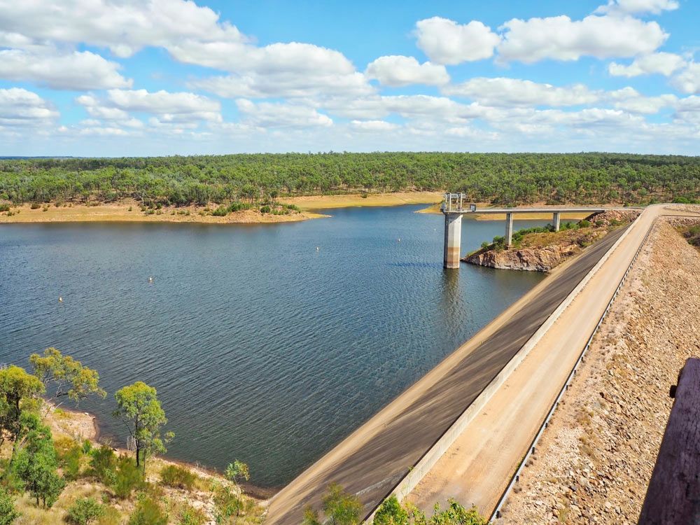 A Large Body of Water Surrounded by Trees and A Bridge — Watto's Earthmoving & Machinery Hire in Atherton, QLD
