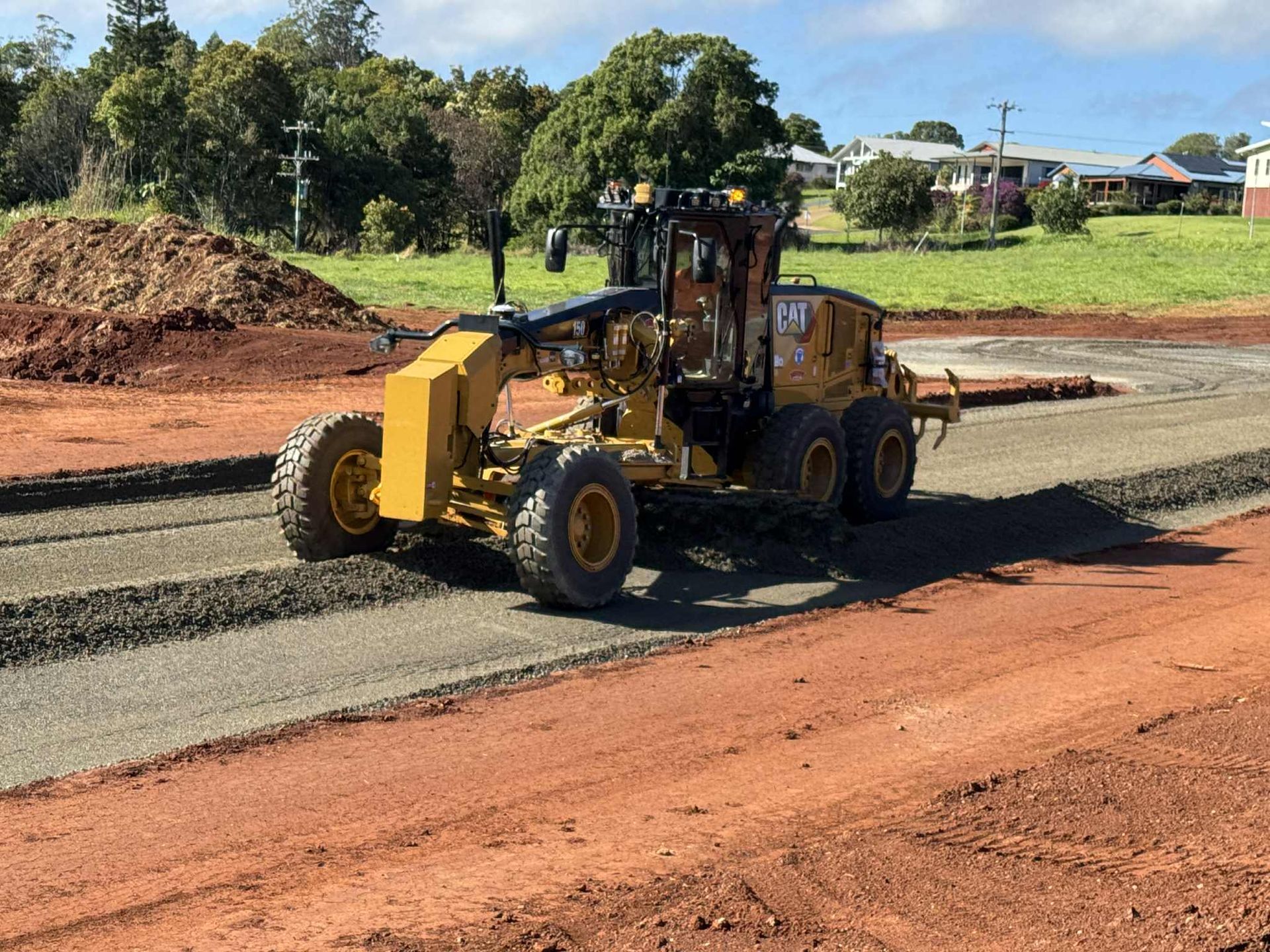 A Man Using a Trowel to Spread Concrete on A Sidewalk — Watto's Earthmoving & Machinery Hire in Atherton, QLD
