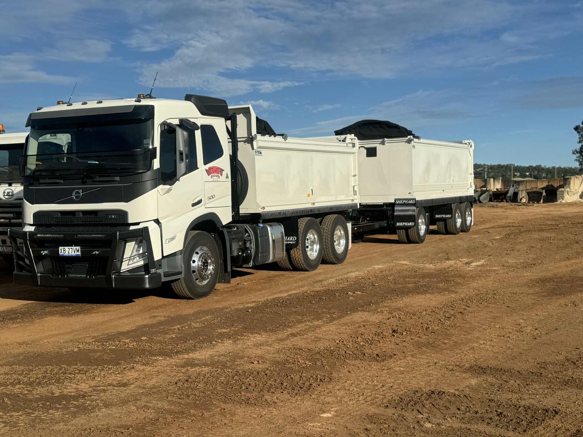 A Yellow Truck Is Drilling a Hole in The Ground — Watto's Earthmoving & Machinery Hire in Atherton, QLD