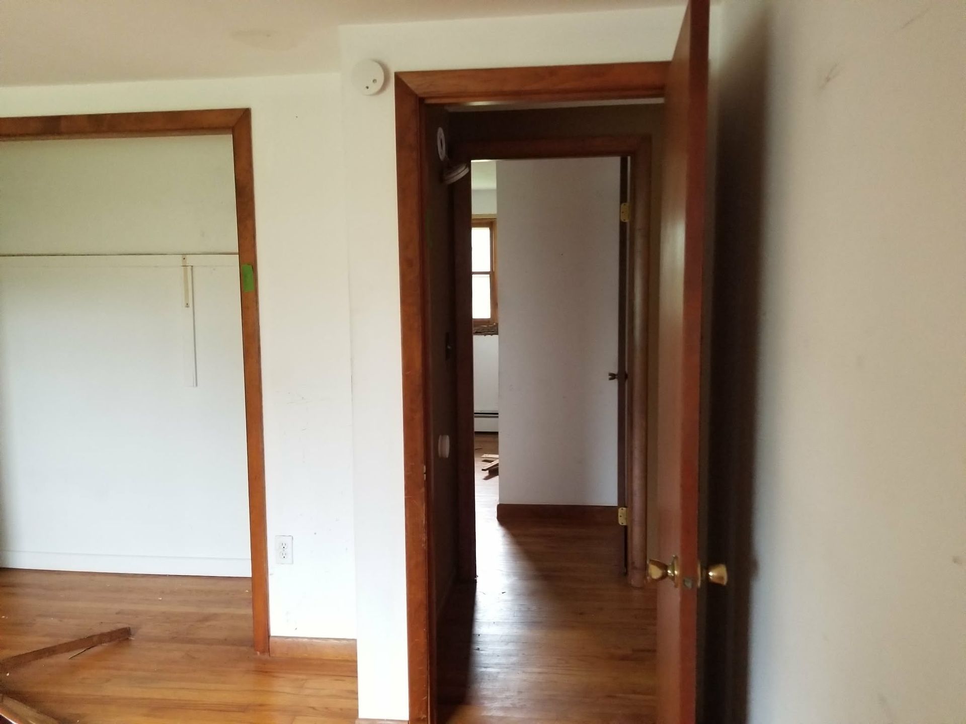 Empty hallway with wooden floors and doorways in a bright interior room
