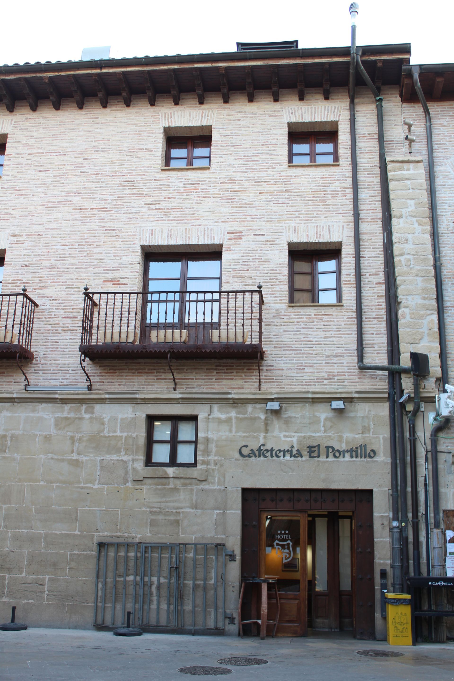 Fachada de piedra con balcones y una puerta con la inscripción “California El Portal”.