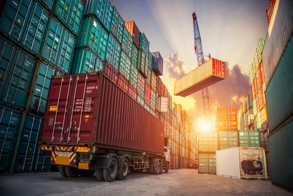 A Truck Is Driving Through a Warehouse Filled with Shipping Containers — Spinifex Container Solutions In Perth, NT